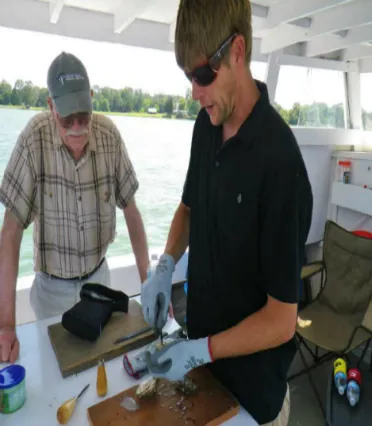 Captain Trey Sowers giving an oyster shucking demonstration aboard the Helen Elizabeth